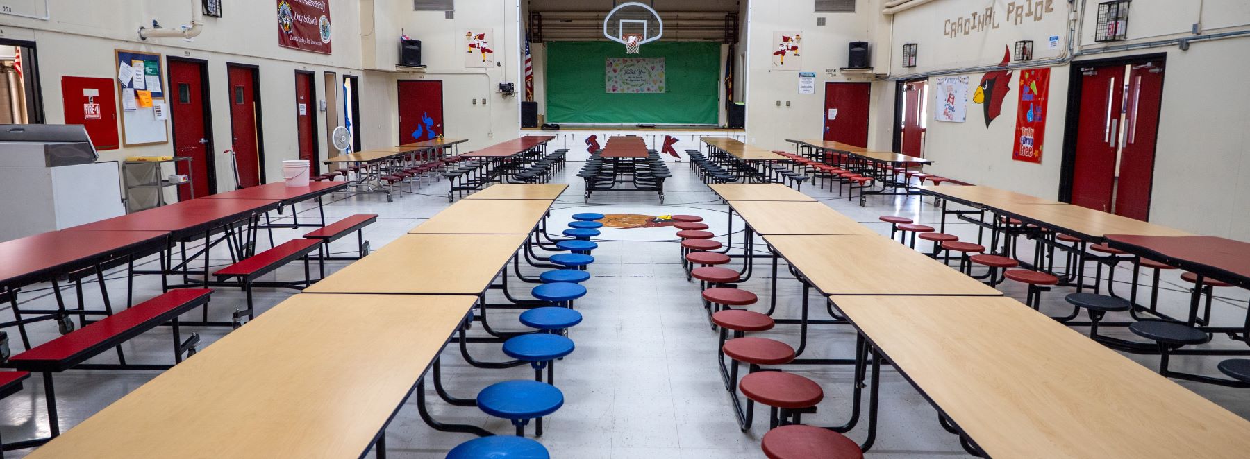 A long cafeteria featuring rows of tables and chairs arranged for dining.