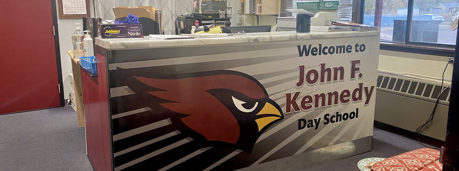 Welcome to John F Kennedy Day School banner on office reception desk.