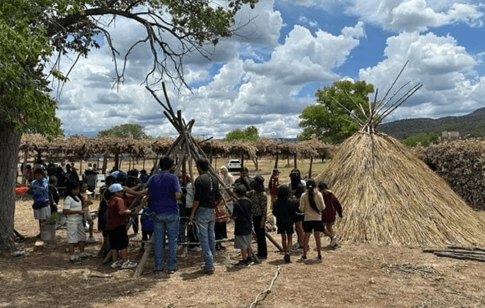 Students building an Apache wickiup at the Fort Apache Museum.